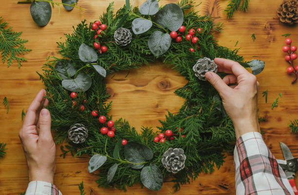 istock Female hands decorate Christmas wreath. 1449836424