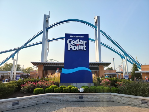 Sandusky, OH, USA - August 20, 2021: The entrance of Cedar Point with the Gatekeeper ride over the top in the evening with a sunset.