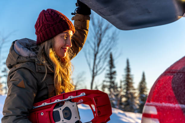 A woman getting ready to go snowshoeing.