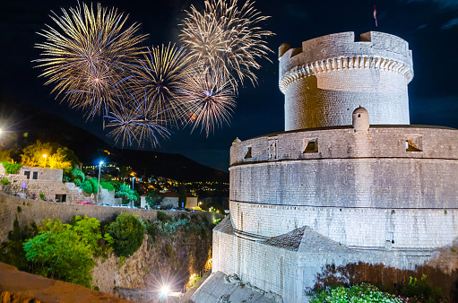 Cozy street and old city walls at night with fireworks in Dubrovnik, Croatia