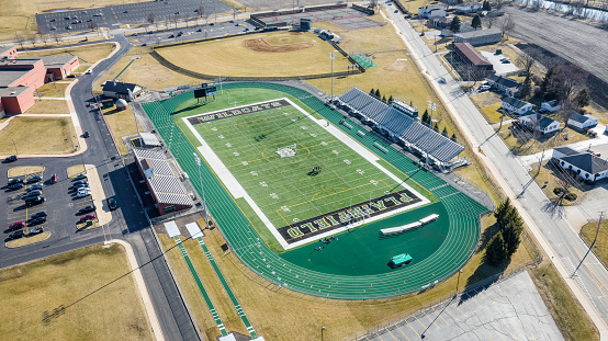 PLAINFIELD, IL, USA - MARCH 19, 2019: A drone/aerial view of the Plainfield Central High School football and soccer stadium, surrounded by a green running track.