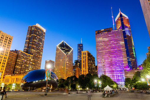 Chicago, IL, USA - August 4, 2019: Millennium Park is located in downtown Chicago, Grant Park, and is surrounded by skyscrapers to make a beautiful skyline. Buildings are lit up in colorful lights.