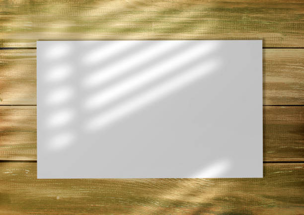 istock Empty white list on an old style wooden empty background with windows blinds shadow 1449840941