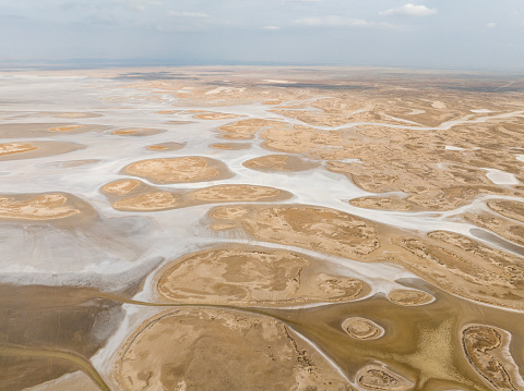 Aerial view of beautiful natural shapes and textures on a dried lake. Salt Lake (Tuz Gölü) located at the intersection of Ankara, Konya and Aksaray provinces in the Central Anatolian Region of Türkiye. Taken via drone.