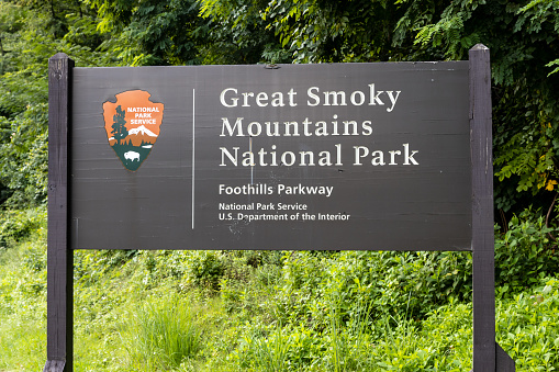 Gatlinburg, TN, USA - August 1, 2022: A Great Smoky Mountains National Park sign on the side of the road.