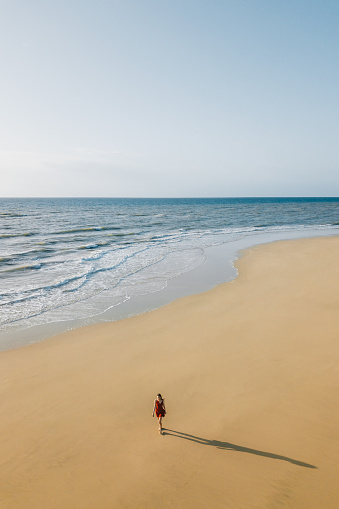 High angle point of view, woman walking on the sand beach