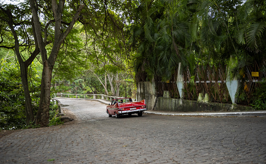 Havana, Cuba, December 10, 2017: View of a vintage car while driving through a public park in Havana.