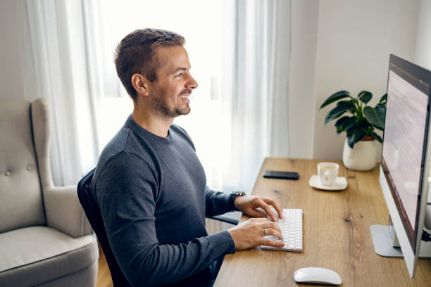 istock A young freelancer is sitting at the home office and typing an email while smiling at the monitor. 1449845188