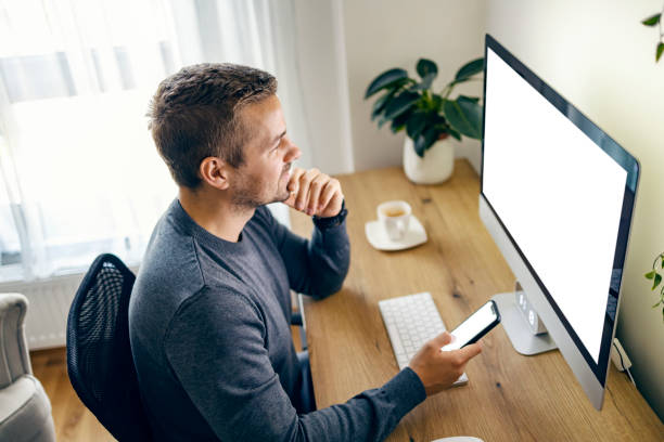 istock A young man is using cutting edge technology for successful business while smiling at the computer monitor. 1449845258