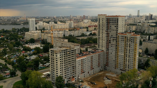 Landscape from a drone.Stock footage.Beautiful view of the city with tall houses and a large lake nearby and a gray sky overhead. High quality 4k footage