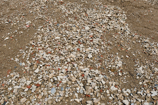 Detail shot from a higher angle of a  large pile of crushed stone and earth for commercial use and blue sky