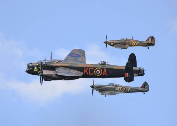 View of Lancaster, Spitfire, and Hurricane of the BBMF flying in the blue sky Lincoln, United Kingdom – June 21, 2019: The view of Lancaster, Spitfire, and Hurricane of the BBMF flying in the blue sky spitfire stock pictures, royalty-free photos & images