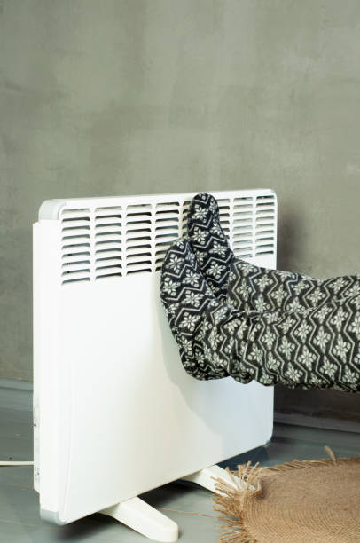 istock girl warms her legs trying to warm herself 1449848462