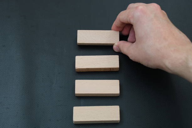 istock man's hand sorting wooden blocks on black background 1449848709