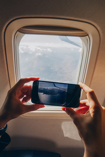 Man taking a photo through airplane window