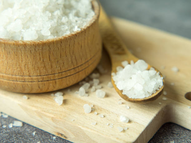 sal de cristal de mar en un tazón de madera y cuchara en una tabla de madera - salt crystal spoon food fotografías e imágenes de stock