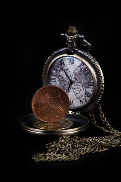 istock Czech coins and vintage clock with a chain on a black background 1449856067
