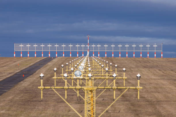 una fila de luces de aterrizaje en un aeropuerto con la antena ils del sistema de aterrizaje intrumental - ils fotografías e imágenes de stock