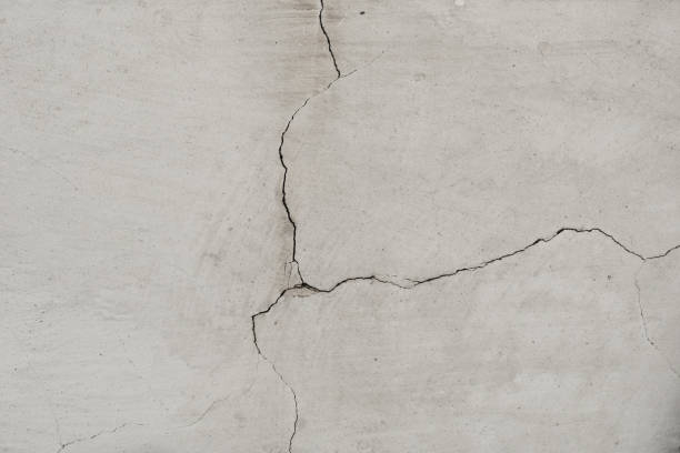 istock Old wall with white plaster and cracked peeling texture in black and white copy space. Grunge cracked concrete wall. Grungy wide brickwall. 1449864860