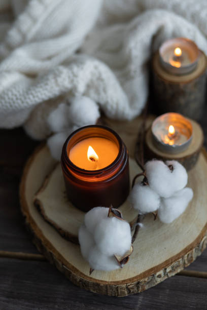 istock Cozy autumn or winter composition with aromatic candle, wool sweater, book. Aromatherapy, home atmosphere of cosiness and relax. Wooden background close up. 1449865702