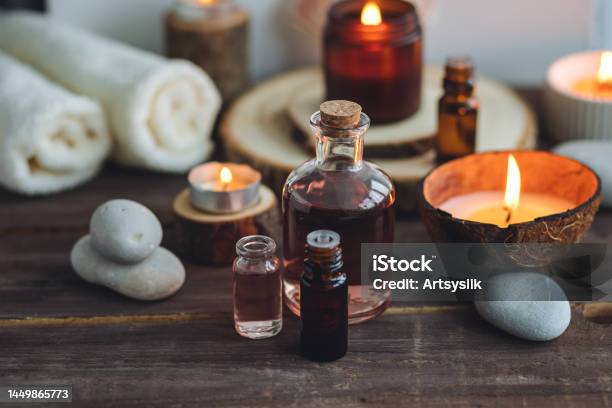 Concept Of Natural Essential Organic Oils Bali Spa Beauty Treatment Relax Time Atmosphere Of Relaxation Pleasure Candles Towels Dark Wooden Background Alternative Oriental Medicine Stock Photo - Download Image Now