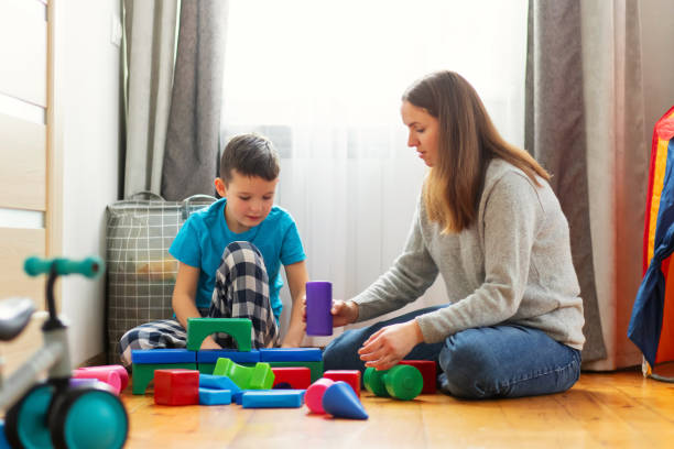 istock Young mother and her son playing together with colorful blocks 1449865924