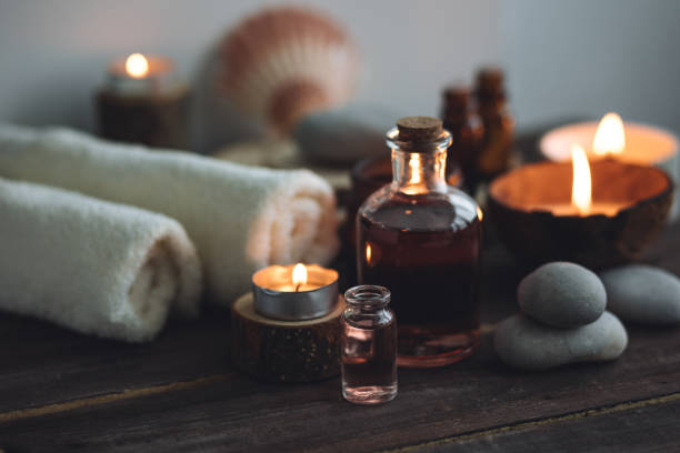 conceito de óleos orgânicos essenciais naturais, bali spa, tratamento de beleza, tempo de relaxamento. atmosfera de relaxamento, prazer. velas, toalhas, fundo de madeira escura. medicina oriental alternativa - aromatherapy oil massage oil alternative therapy massaging - fotografias e filmes do acervo