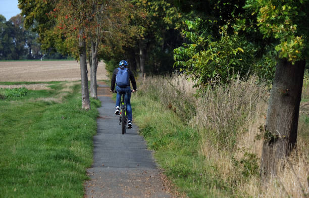 istock Cyclist with backpack and helmet on a asphalt bike path 1449867469