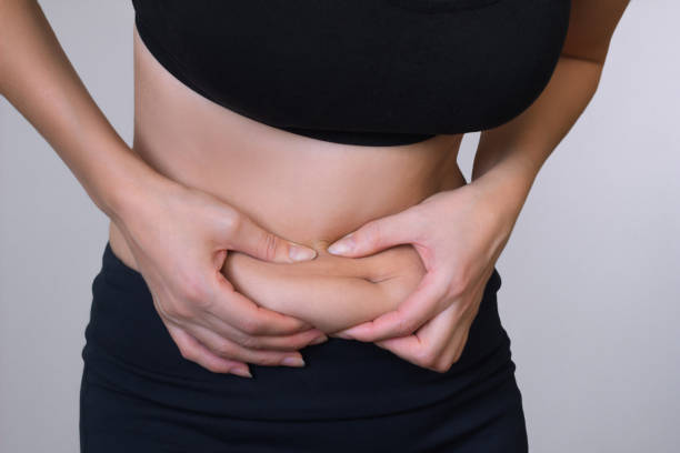 istock Woman hand holding excessive belly fat 1449867798