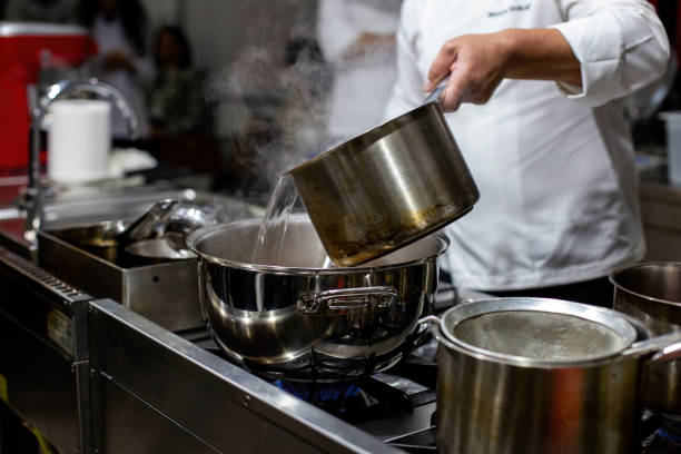 istock The cook pours hot water from pot to pot. 1449867846