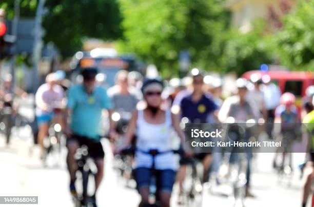Blurred Image Of A Group Of Cyclists In Light Clothing On A City Street In Summer Stock Photo - Download Image Now
