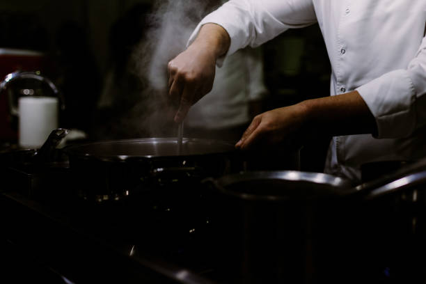 istock A cook stirring pots in the kitchen. Big pots in the kitchen 1449868878