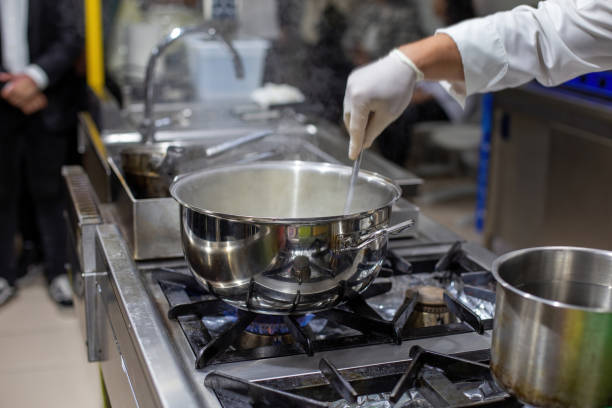 istock A cook stirring pots in the kitchen. Big pots in the kitchen 1449869109