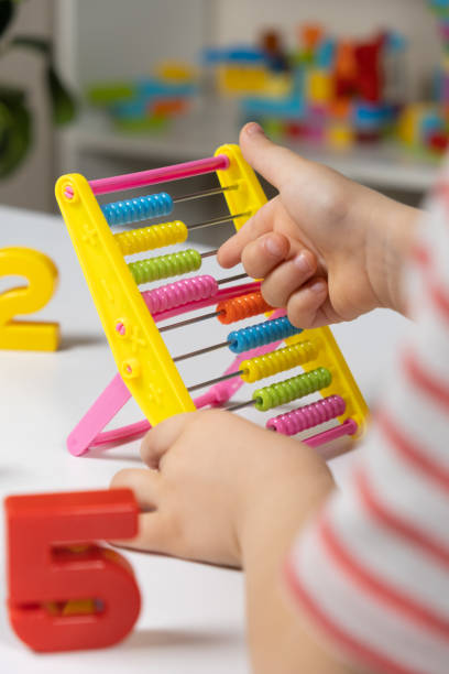 istock A small child learns to count on abacus, mathematics, arithmetic for children. 1449871705