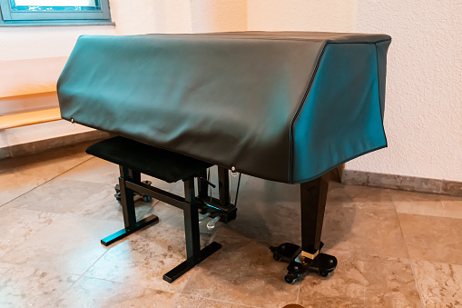 leather cape cover on the piano in the concert hall