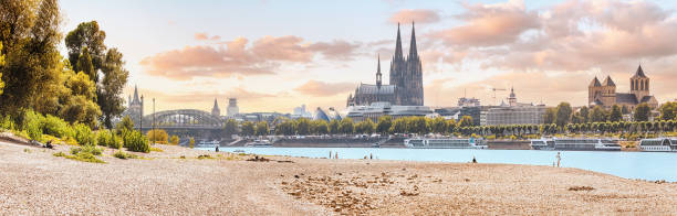 istock Panoramic view of the Rhine River beach and the Cologne skyline with recognizable architectural silhouettes of the famous Koln Cathedral 1449874730