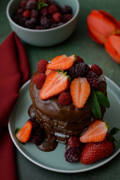 istock Vertical closeup of chocolate pancakes decorated with berries 1449876961