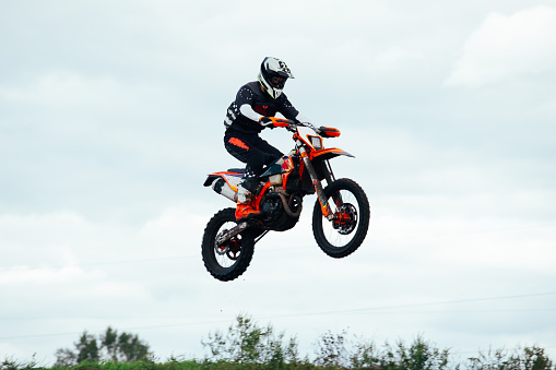 Jump, people and motorbike with exercise, competition and challenge with safety, fitness and performance. Athletes, sand and bikers with mockup, practice and cycling with freedom, workout and energy