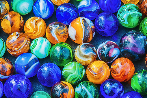 A collection of well used colorful glass marbles from  children's play in the past.