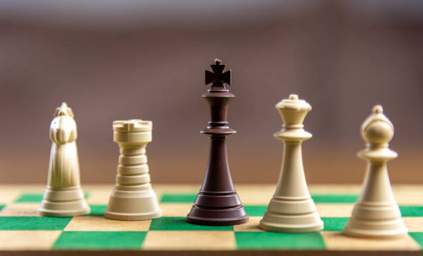 istock Chess game pieces on the green board 1449892725