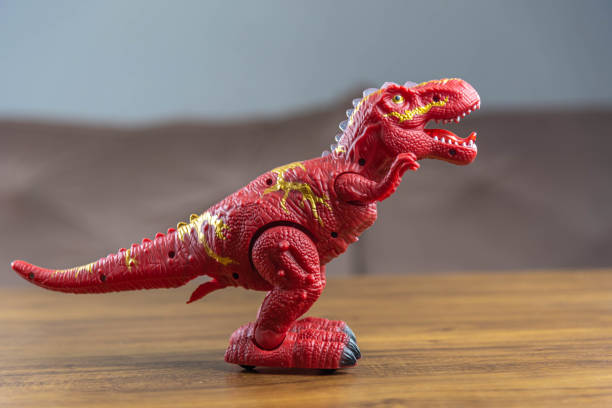 istock Toy dinosaurs on wooden surface 1449894736