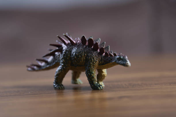 istock Toy dinosaurs on wooden surface 1449894751