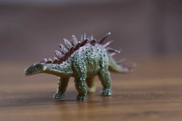 istock Toy dinosaurs on wooden surface 1449894753