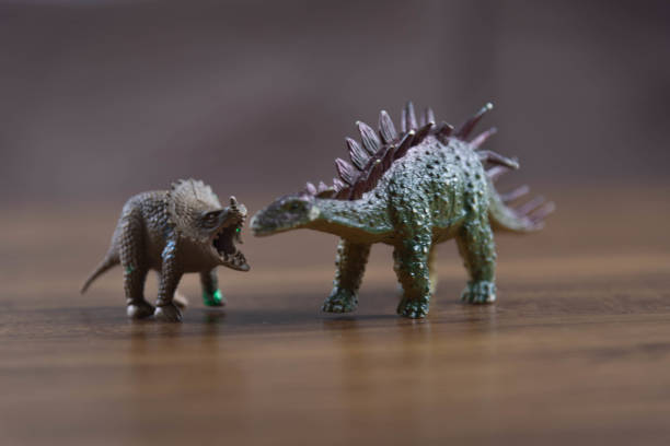 istock Toy dinosaurs on wooden surface 1449894760