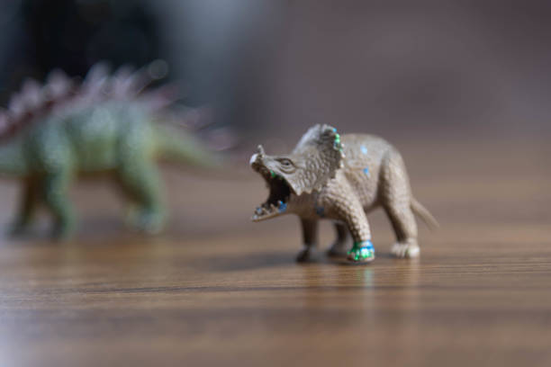 istock Toy dinosaurs on wooden surface 1449894762