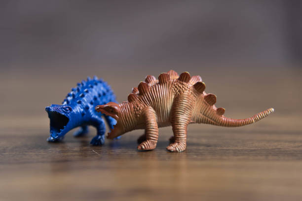istock Toy dinosaurs on wooden surface 1449894776