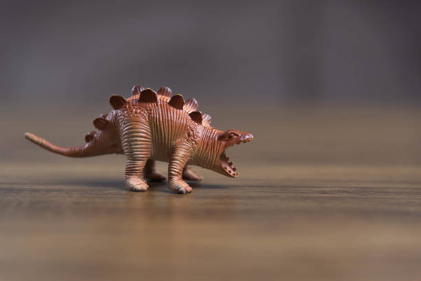 istock Toy dinosaurs on wooden surface 1449894779