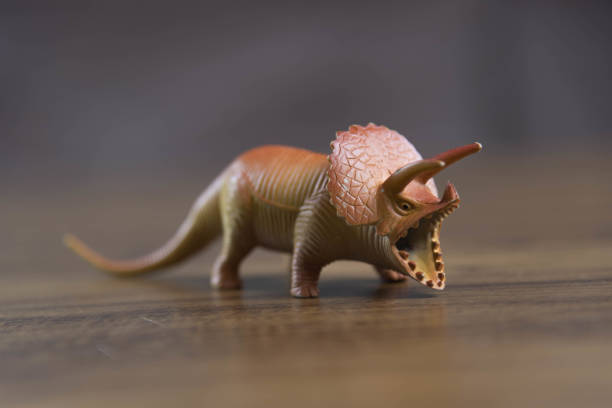 istock Toy dinosaurs on wooden surface 1449894780