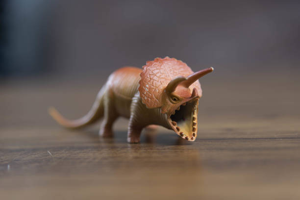 istock Toy dinosaurs on wooden surface 1449894787