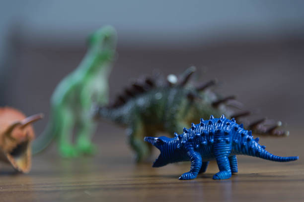 istock Toy dinosaurs on wooden surface 1449894797